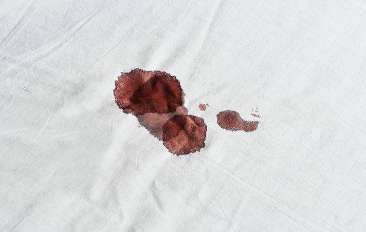 Mancha de sangre en una sábana blanca