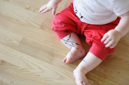Bebé con marcador en sus piernas